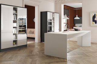 a modern white kitchen with large kitchen island and a herringbone wood floor