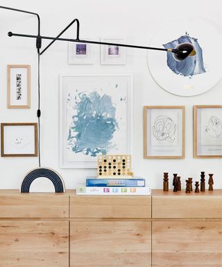 emily henderson's dining room gallery wall filled with artwork by her chiildren