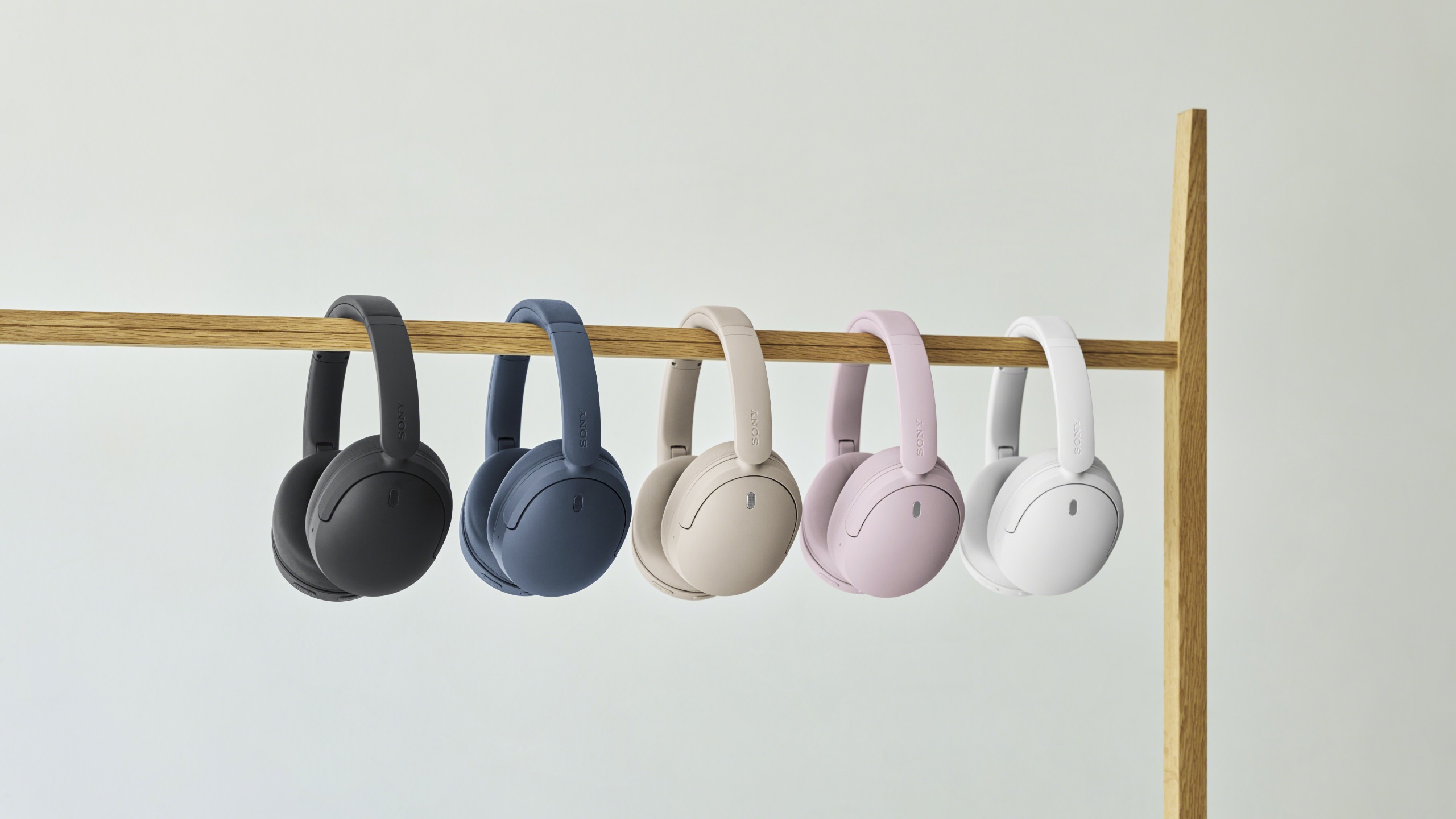 Sony WH-CH730N wireless headphones in various colours hung from a wooden beam