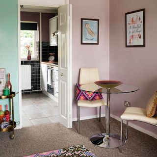pink wall dining room with table and carpet flooring