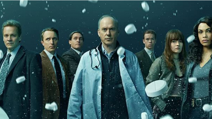 The cast of Dopesick with pills falling down around them