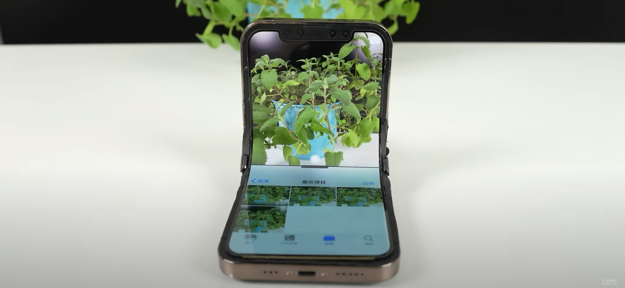 A still image of a primtive foldable iPhone design, taking a picture of a plant