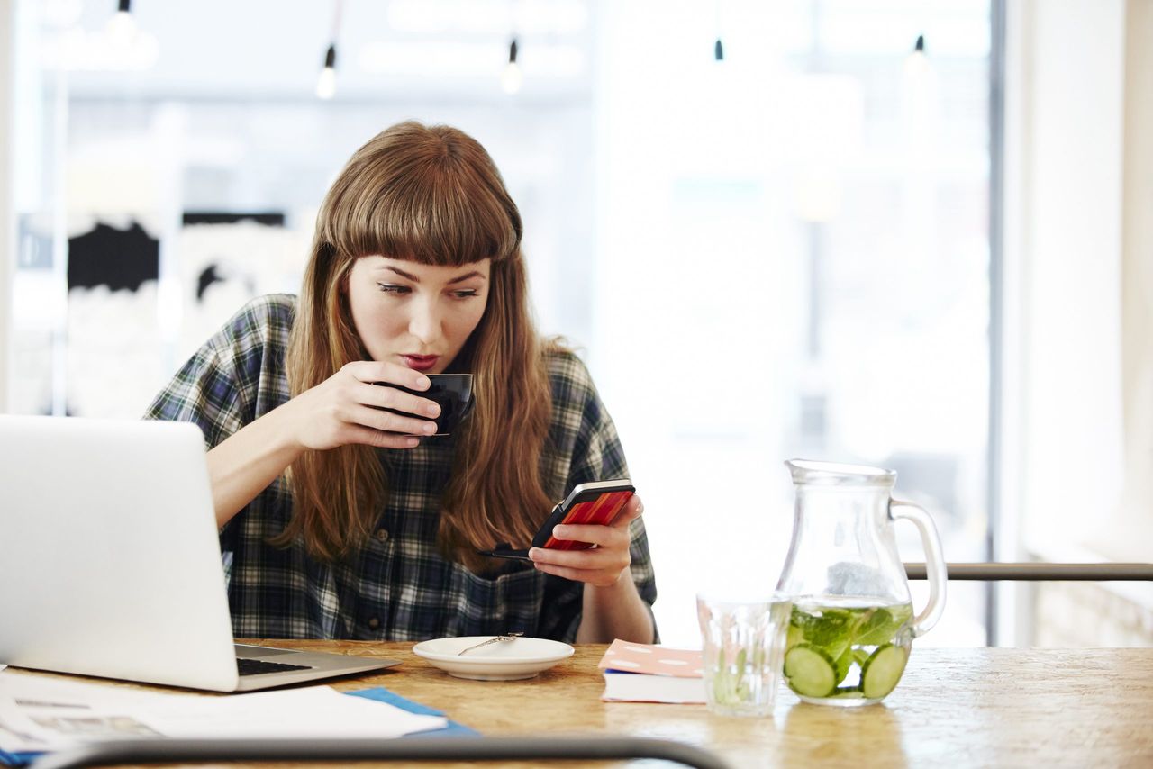 Healthtech: Girl drinking coffee checking her phone