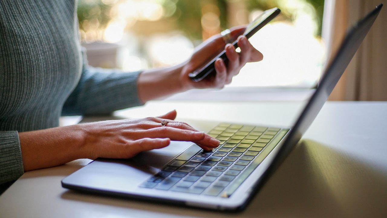 A woman on a laptop and mobile phone 