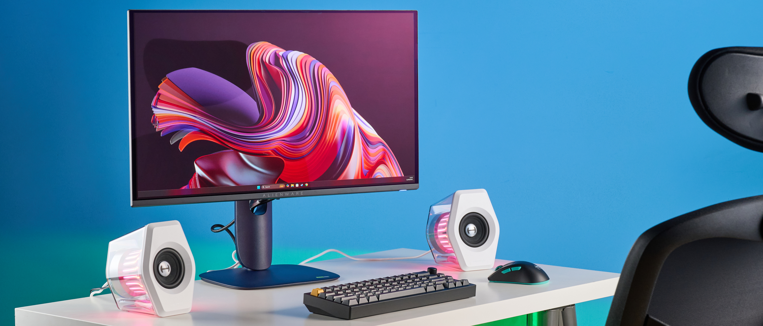 Alienware AW2725D on a desk against a blue background