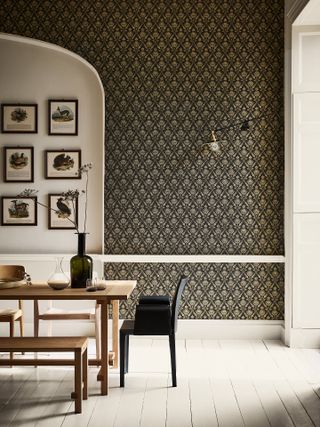 Dark print wallpaper complemented with white trim and gallery wall