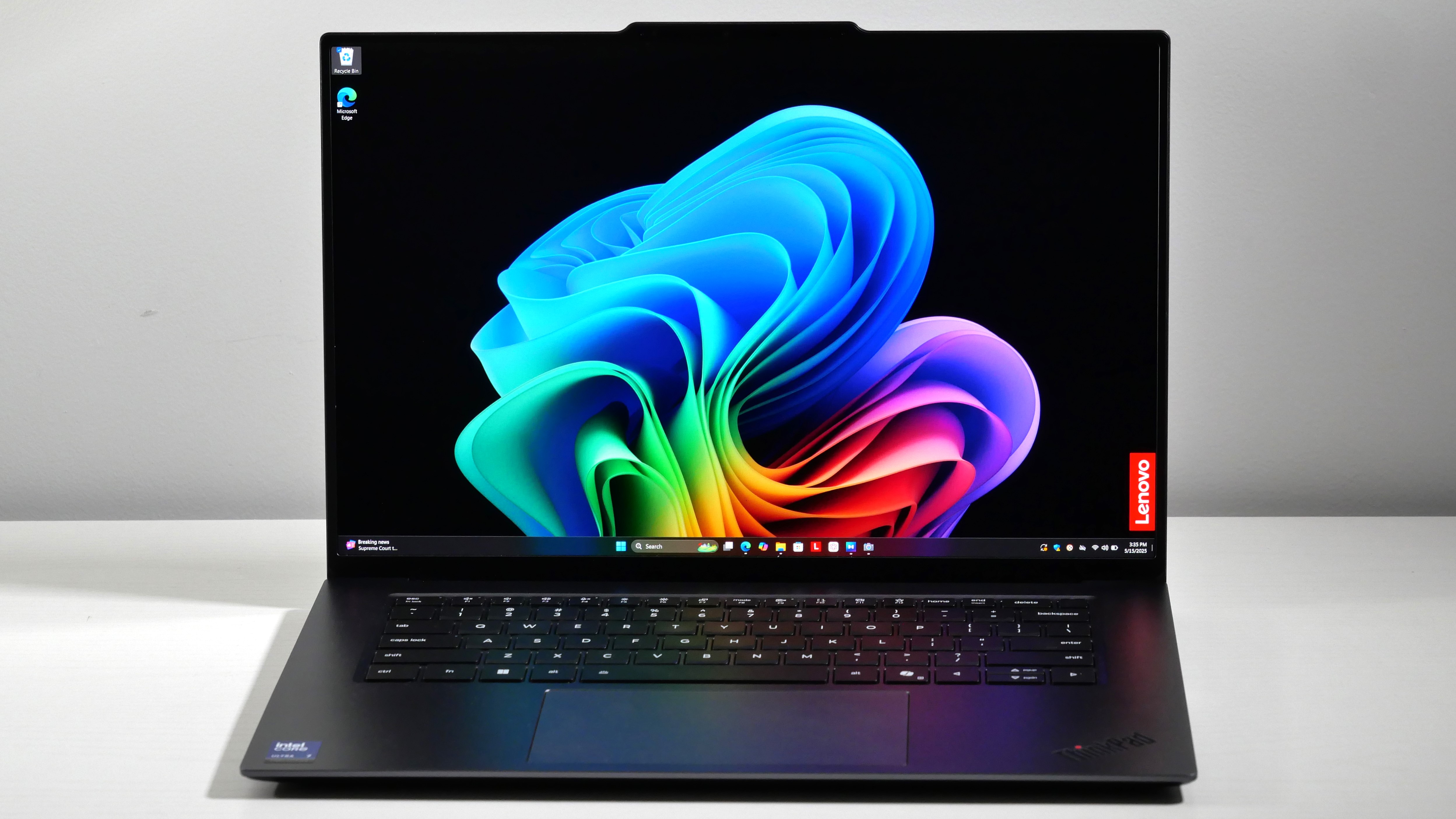 Lenovo ThinkPad X9-15 Gen 1 Aura Edition open on a white desk, highlighting the stunning OLED display.