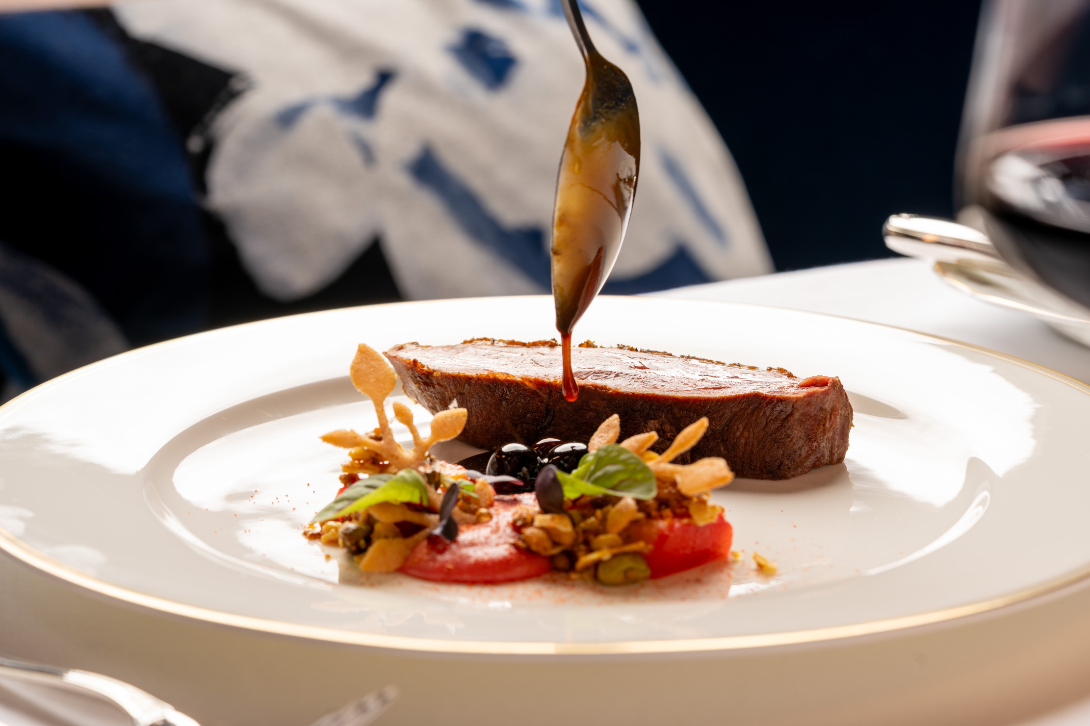 A plate of beef with ornately prepared salad