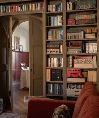dark neutral living room with built in bookshelves and arched doorway to dining room