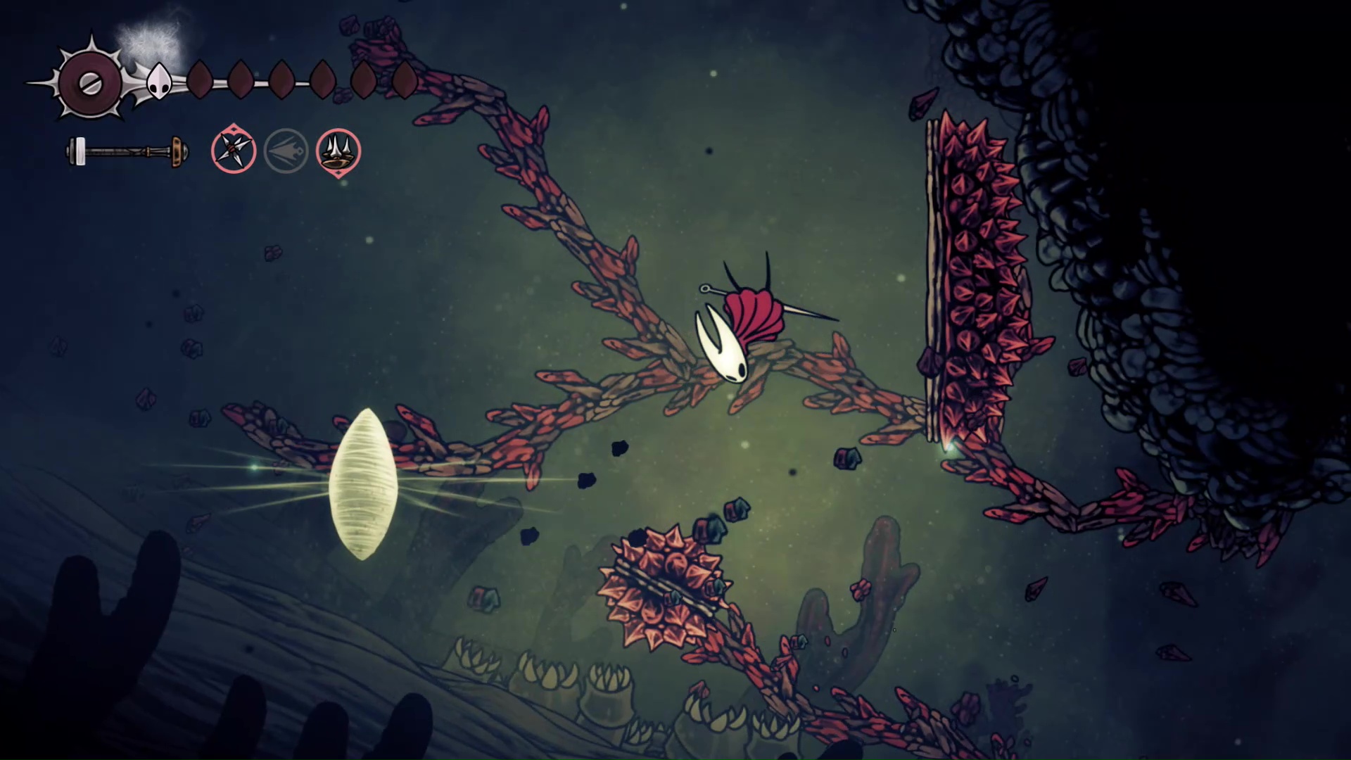 Hornet jumps between spiky platforms in Hollow Knight: Silksong within the Sands of Karak - her death cocoon nearby