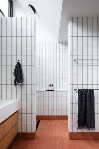 A bathroom with red terracotta floor tiles