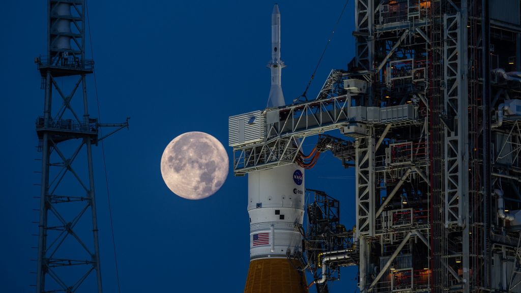 The strawberry supermoon rises behind the Artemis 1 moon rocket on June 14, 2022.