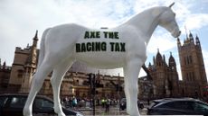 A model horse bearing the slogan "ace the racing tax" outside the Houses of Parliament in London