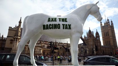 A model horse bearing the slogan "ace the racing tax" outside the Houses of Parliament in London