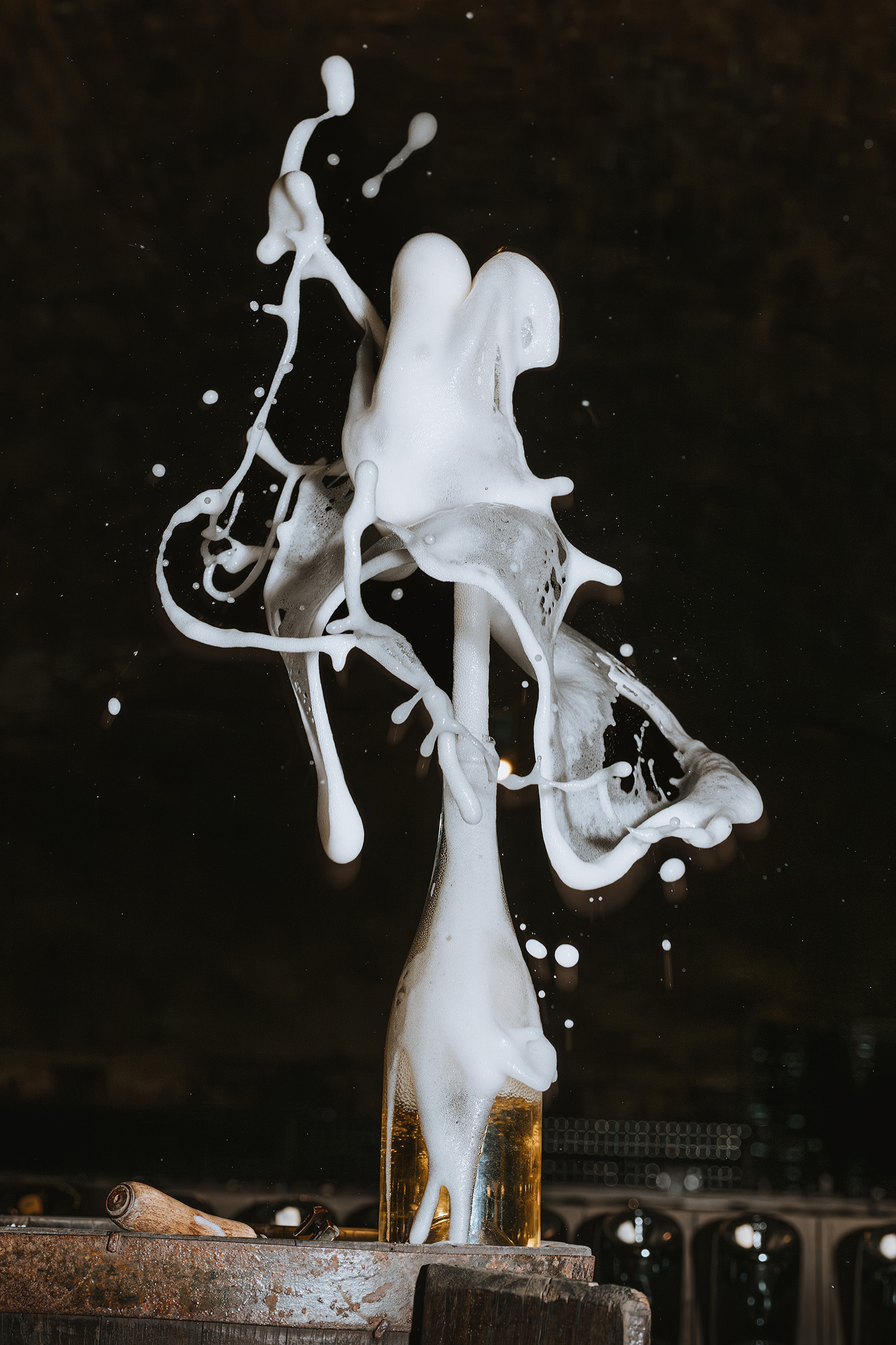 Champagne bottle on a wooden barrel erupts with foam, creating dynamic, swirling patterns