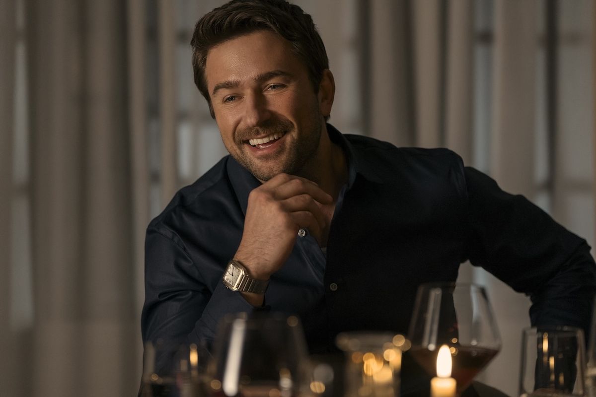Brandon Sklenar smiling at a table in The Housemaid