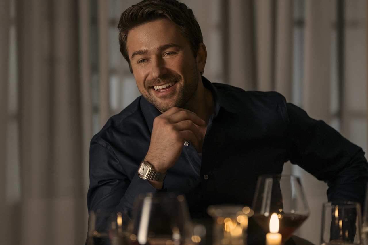 Brandon Sklenar smiling at a table in The Housemaid