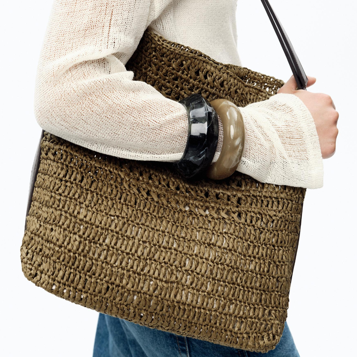 woman wearing a raffia bag and bangles 
