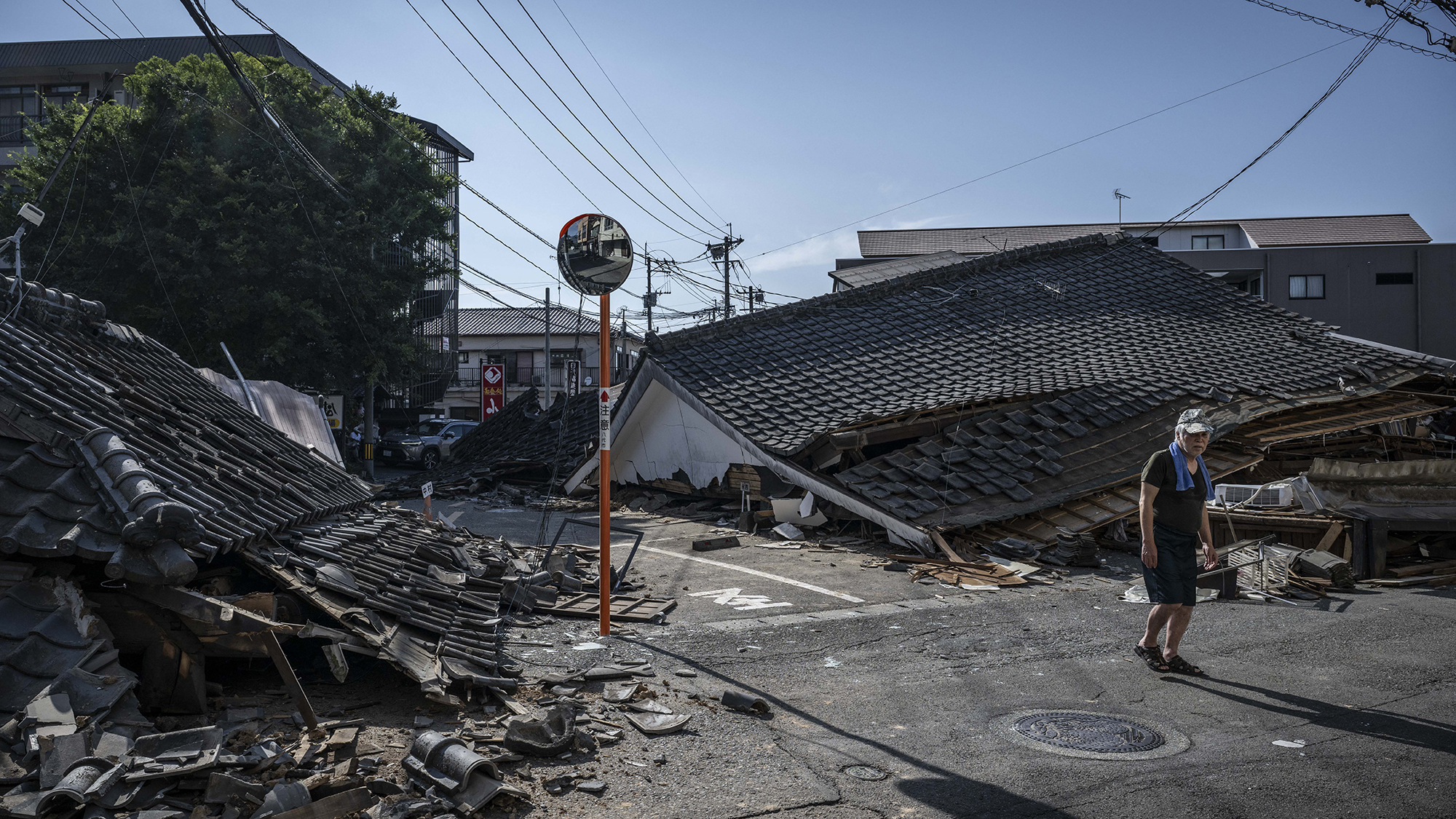 A man walks past collapsed houses in Yatsushiro following a 6.8 magnitude earthquake in Kumamoto prefecture, Japan