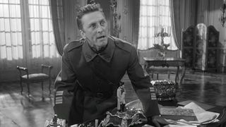 Kirk Douglas as a World War I colonel stands over his desk in Paths of Glory