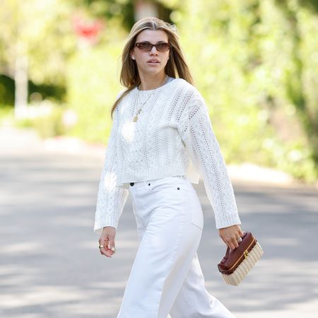 Sofia Richie Grainge wearing a white sweater and jeans