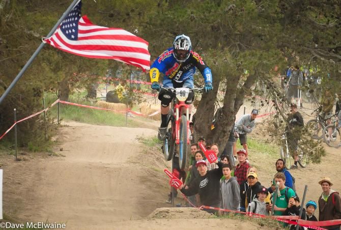 A rider flies past the American flag near the top of the track