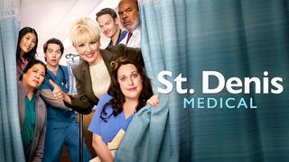 Wendi McLendon-Covey in the centre of the cast of St. Denis Medical pulling various faces and framed by a blue curtain in a hospital setting. 