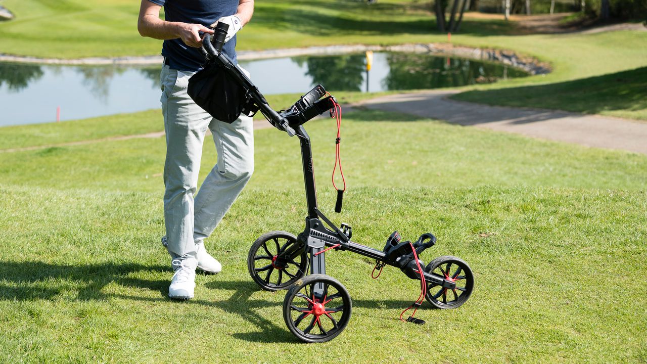 A golfer sets up the Bag Boy Nitron Push Cart