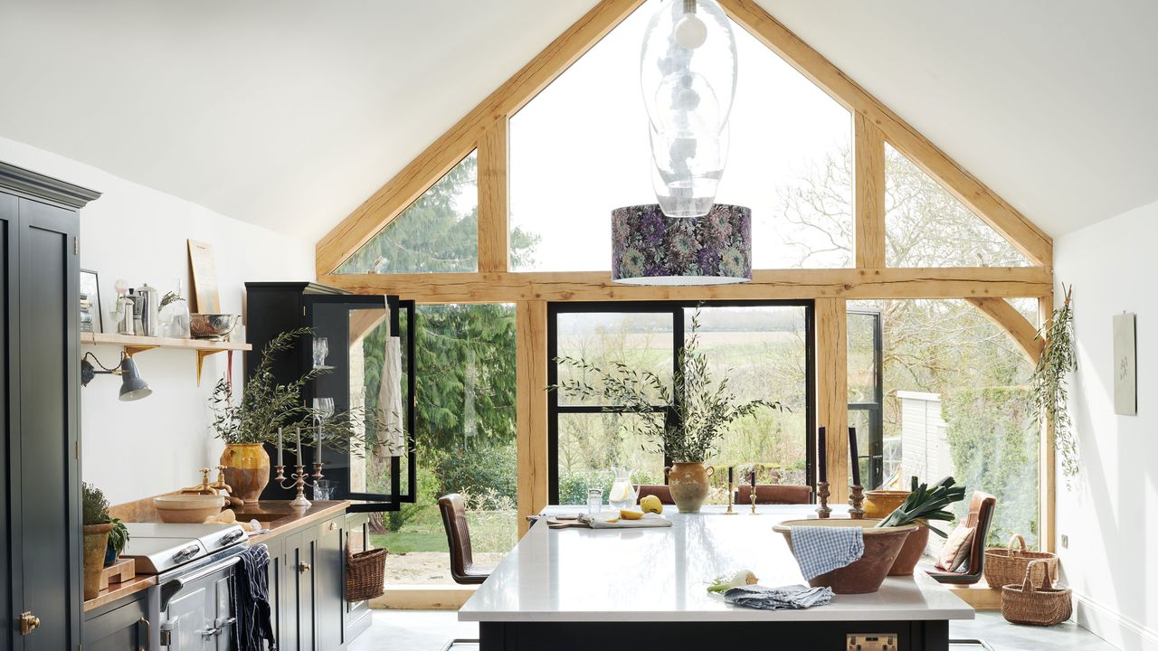 Modern Shaker style kitchen with vaulted ceiling and floor to ceiling glass door and wall