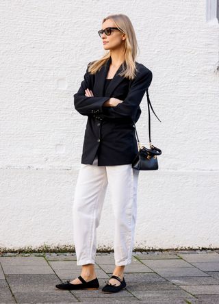 Model and influencer Marlies-Pia Pfeiffhofer wearing a black blazer and white jeans from Mango, black ballerinas and a black shoulder bag by Miu Miu, and sunglasses by Ray-Ban