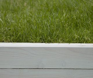 Lawn edged with light grey coloured timber edging