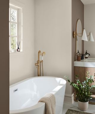 neutral bathroom with bath in front of a window and modern decor