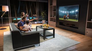 A family watching soccer on a large TV