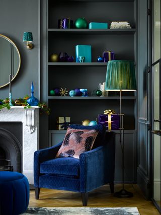 A metallic blue and teal cozy reading corner in festively-themed living room with Pooky Bamboozle Wall light, £57, 14cm shade in Matthew Williamson Leopard Love Jade, £33, Slider Floor lamp