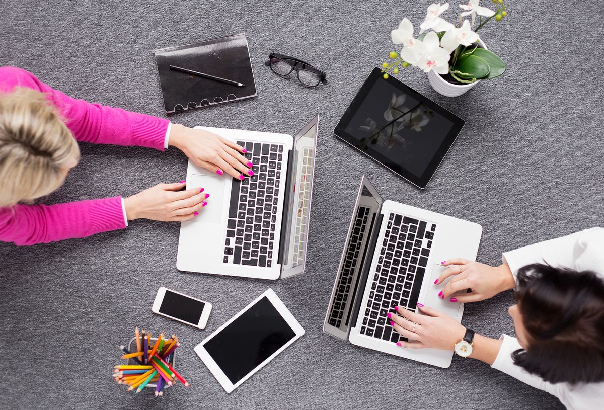 two creative women working on laptops