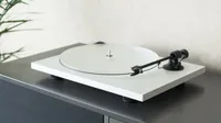A photo of the Pro-Ject Primary E record player on a gray desk