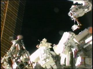 Spacewalking astronauts Sunita Williams (left) and Akihiko Hoshide (right) work outside the INternational Space Station near the outpost's robotic arm on Sept. 5, 2012.
