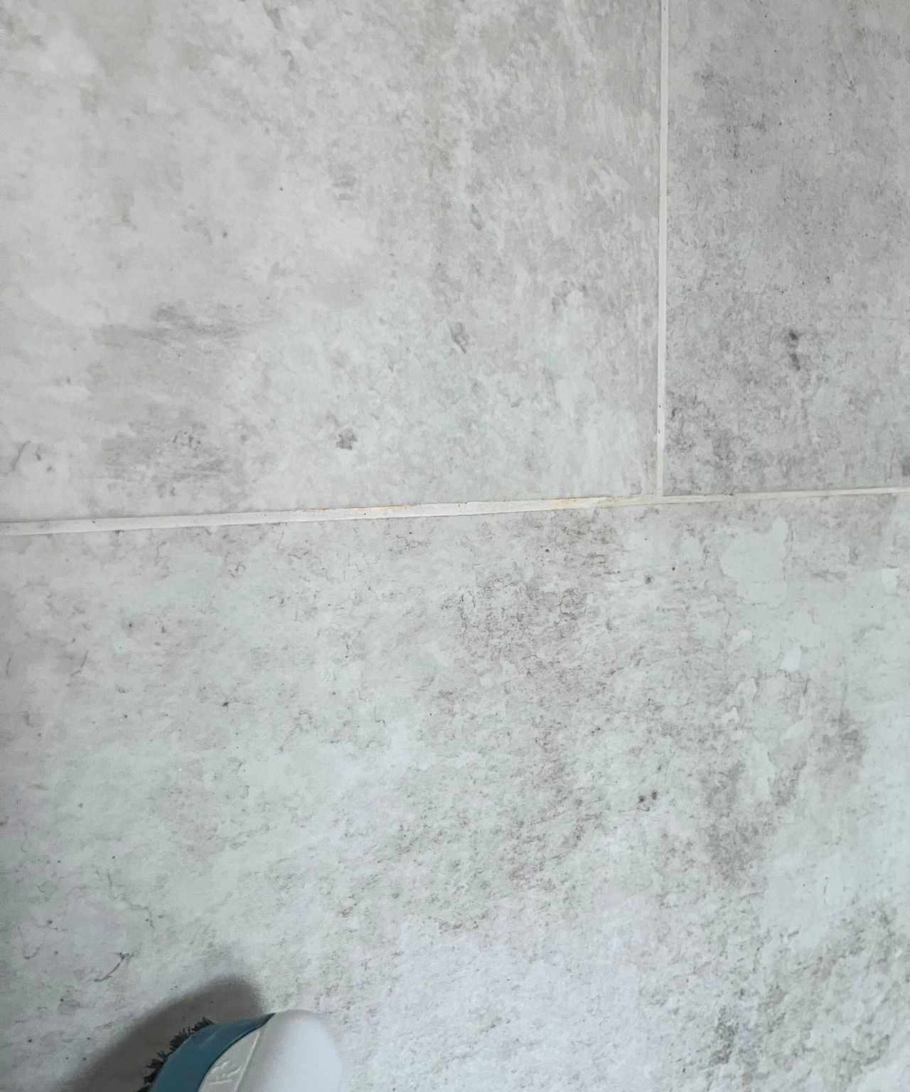 Steam cleaning white grout in grey shower tiles