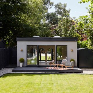 Lawned garden with modern garden office at the end