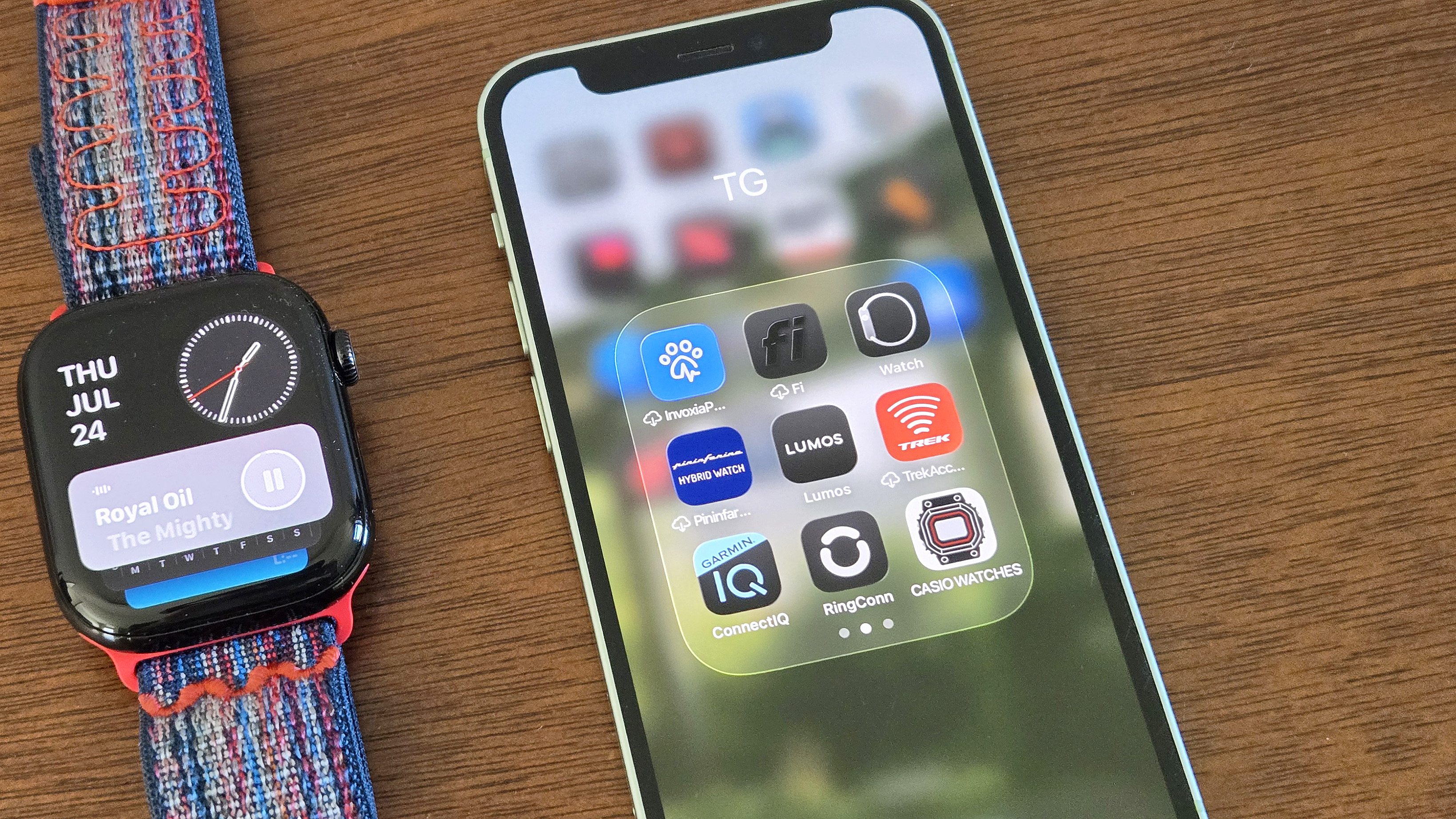 Close-up of the installation process for watchOS 26 showing an Apple Watch Series 10 and iPhone 12 Mini