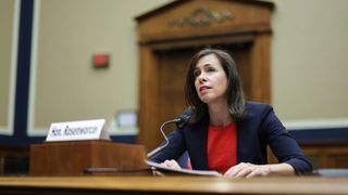 FCC Chairwoman Jessica Rosenworcel, sat at a podium speaking into a microphone