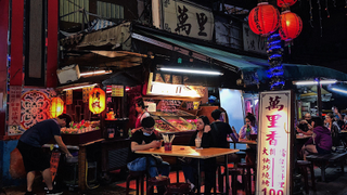 Diners sit at outdoor tables at a restaurant in Tapei