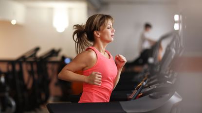 Woman running on treadmill at fitness center