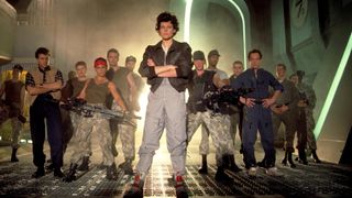 Ellen Ripley looks directly at the camera with her arms folded while other characters pose behind her