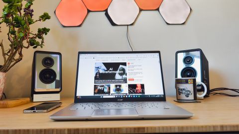 A silver Acer Swift 3 laptop on a light wooden desk