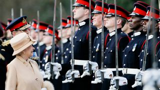 Queen Elizabeth II as proud grandmother smiles at Prince Harry as she inspects soldiers at their passing-out Sovereign's Parade at Sandhurst Military Academy on April 12, 2006 in Surrey, England.