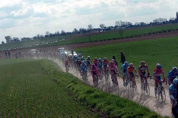 The colours of the peloton through the green fields