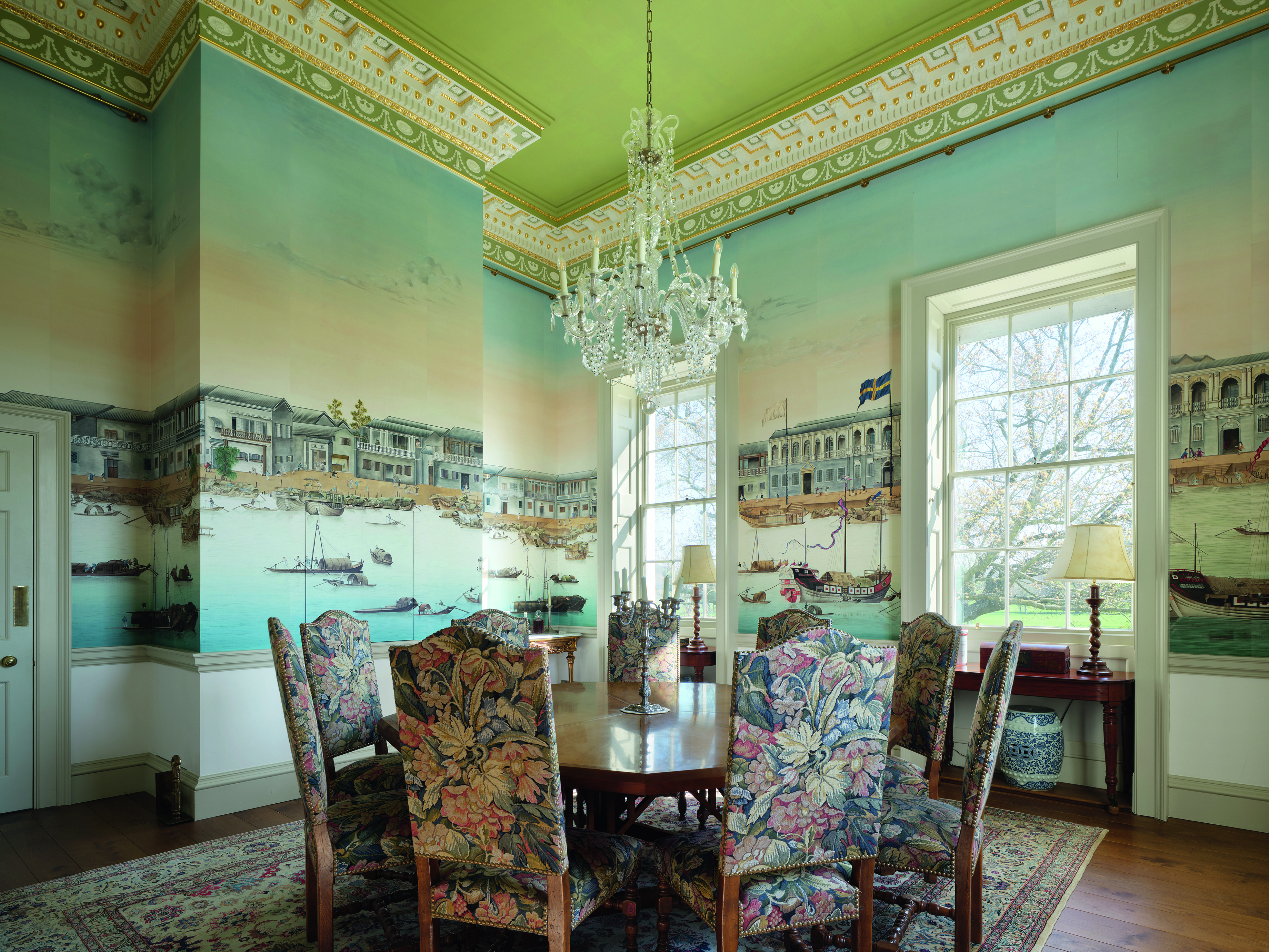 A nautical-themed living room with a dining table and floral chairs