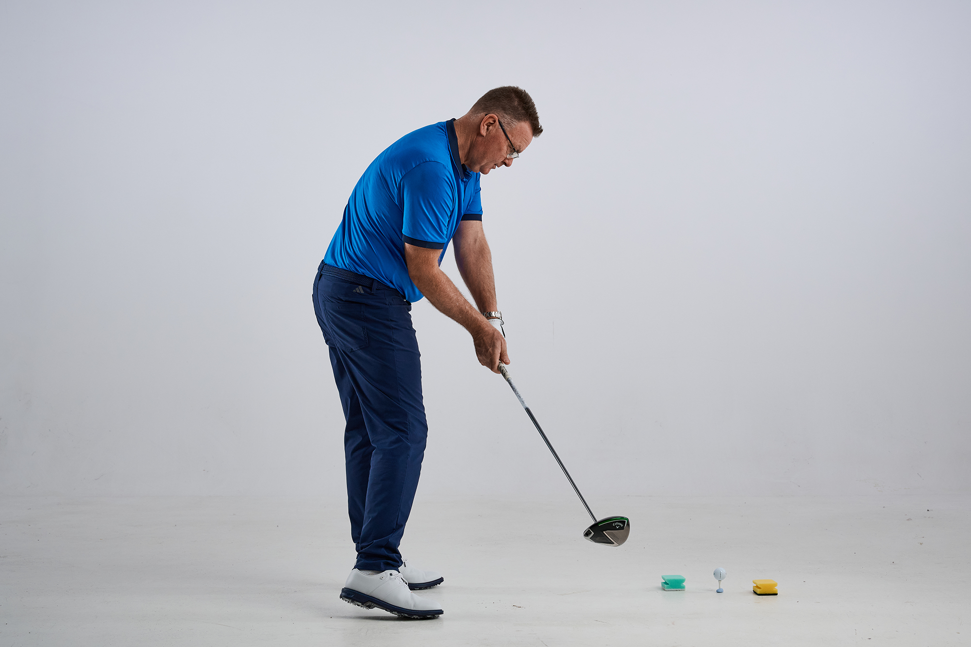 John Jacobs demonstrating a good angle of attack, with the club head preparing to move through the gate created by the kitchen sponges and hit the golf ball square at impact with a neutral flight