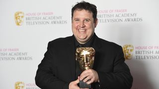 Peter Kay poses with his BAFTA Award for Male Performance in a Comedy Programme for Car Share in 2016.
